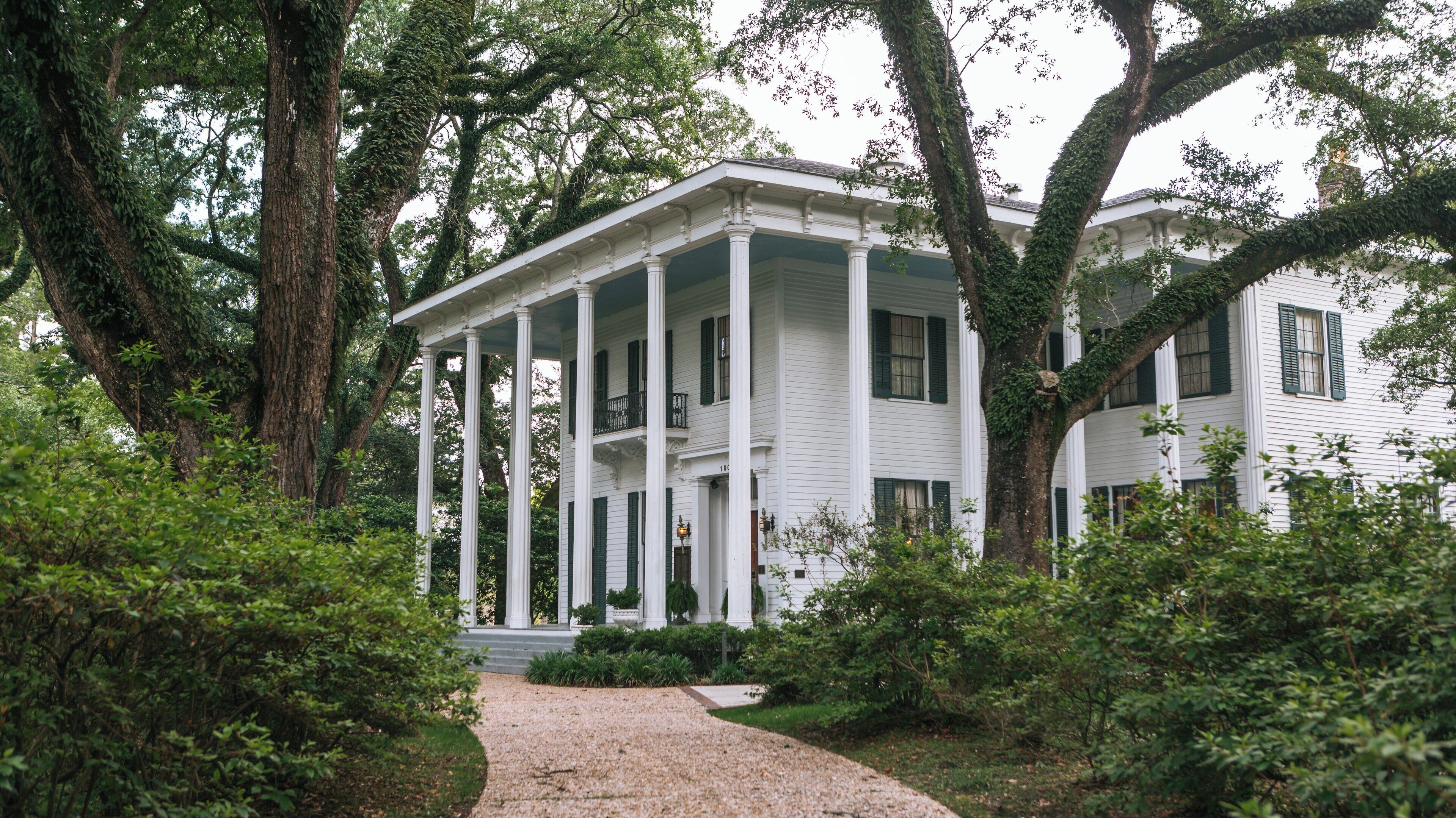 Historic Bragg-Mitchell Mansion set amidst lush greenery in Mobile, Alabama, showcasing classical architecture and Southern charm