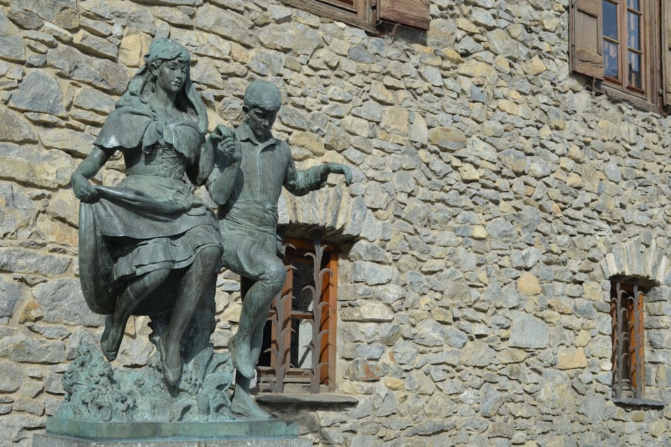 Um edifício de pedra com uma estátua de um homem e uma mulher.