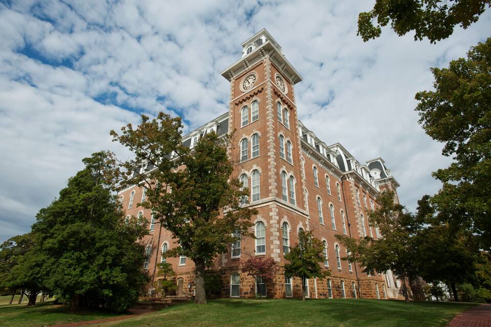 A large brick building with a clock tower and multiple windows.