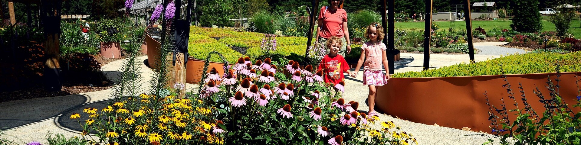Botanical Garden of the Ozarks mostrando um jardim e flores assim como uma família