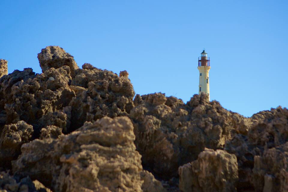 Un paisaje rocoso con un faro en la cima.