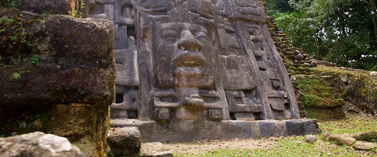A stone pyramid with intricate carvings and a large face at the top.