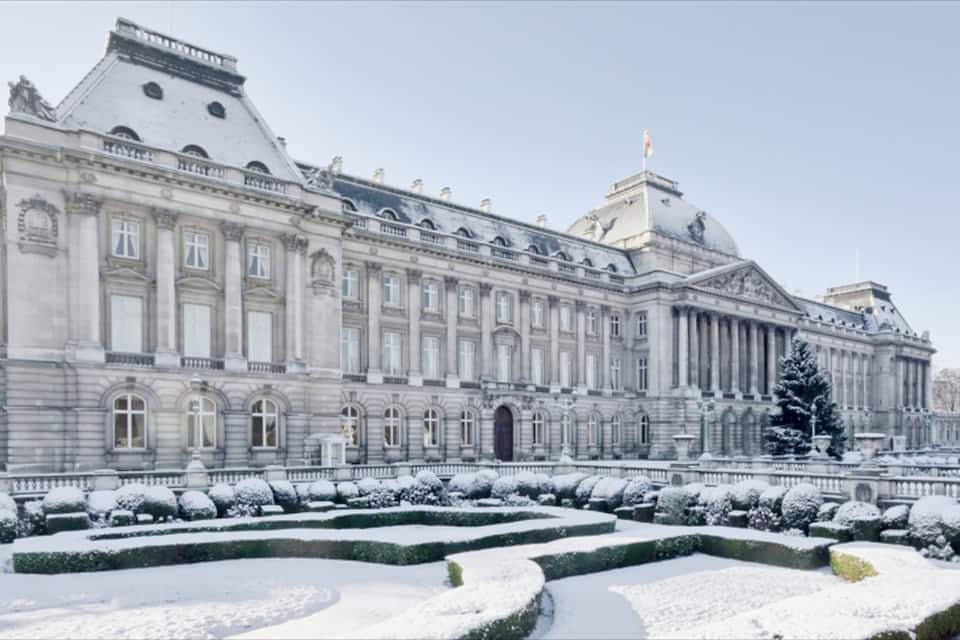 A grand, snow-covered building with classical architecture, including columns and a dome.