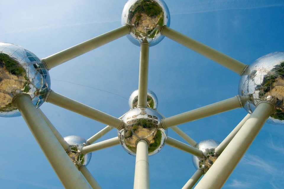Une structure sphérique à la surface réfléchissante, se détachant sur un ciel bleu clair.