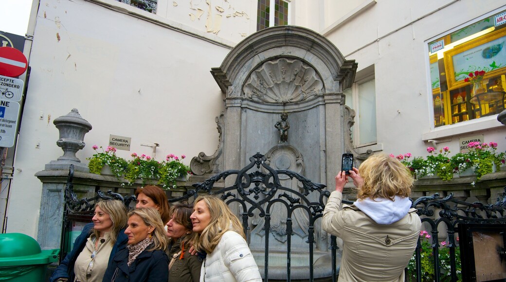 Manneken Pis assim como um pequeno grupo de pessoas