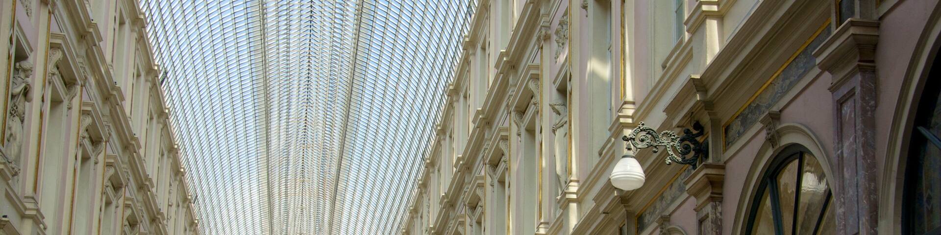 A grand, ornate building with a glass ceiling and rows of columns.