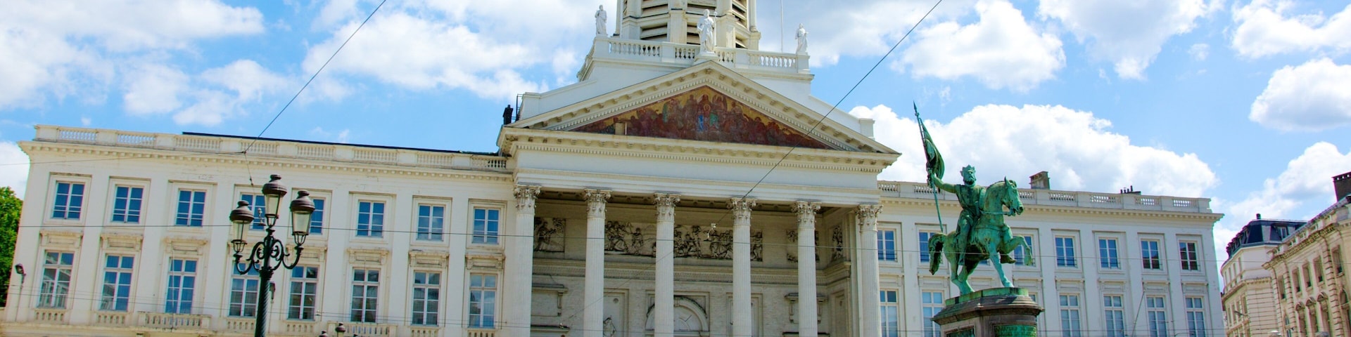 Palácio Real que inclui uma estátua ou escultura, um castelo e uma praça ou plaza