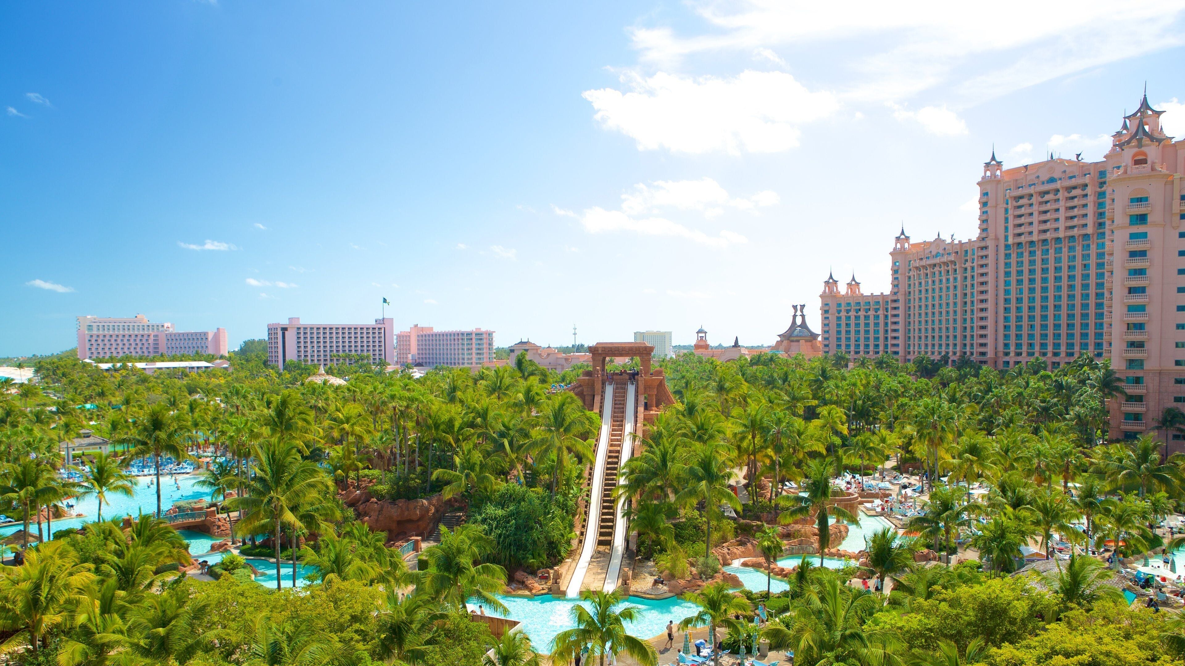 Un complejo turístico con tobogán acuático, palmeras y varios edificios de hotel.