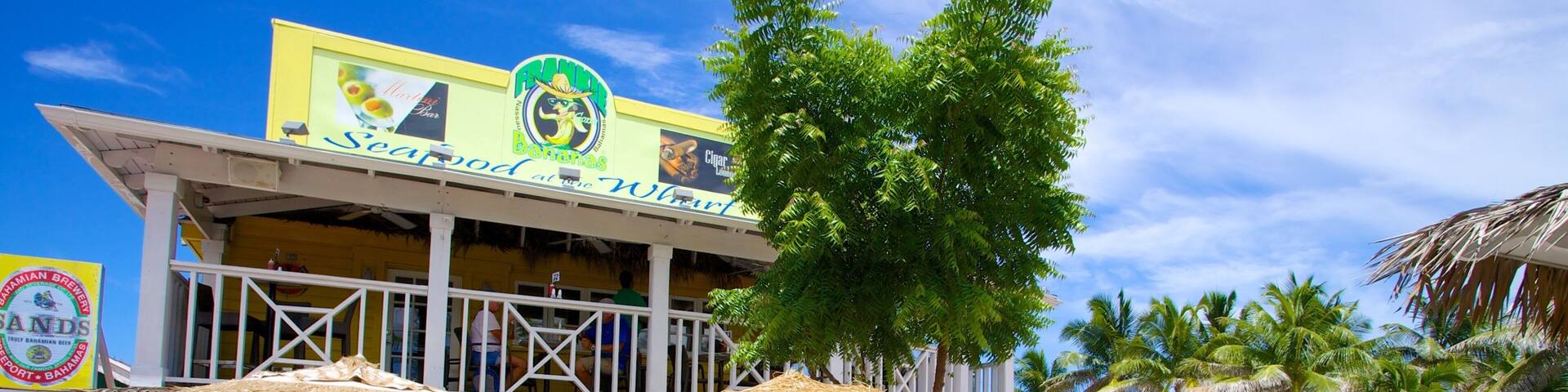 Arawak Cay which includes a coastal town, street scenes and cafe scenes