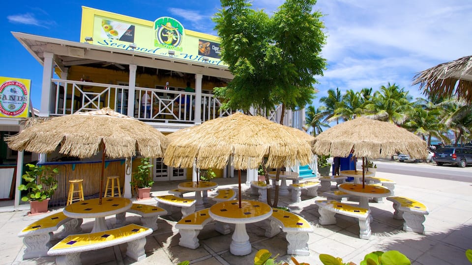 A beachfront restaurant with thatched umbrellas and yellow-tiled tables.