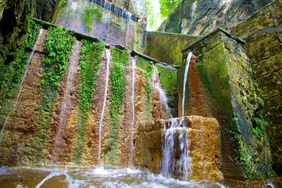 Uma cascata em vários níveis, com paredões rochosos cobertos de musgo.
