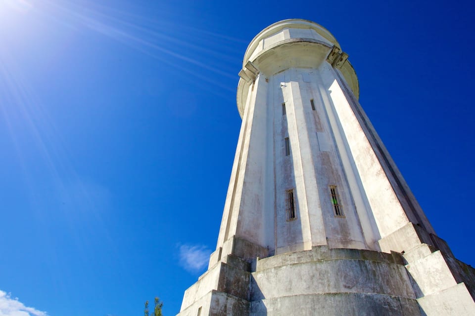 Una torre alta i cilíndrica amb una cúpula, davant d'un cel blau clar.
