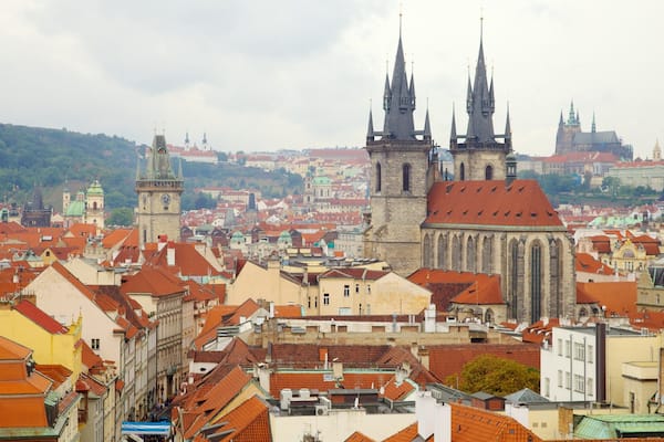 Eine Stadtansicht mit historischen Gebäuden, einer markanten Kirche mit zwei Türmen und einem Glockenturm.