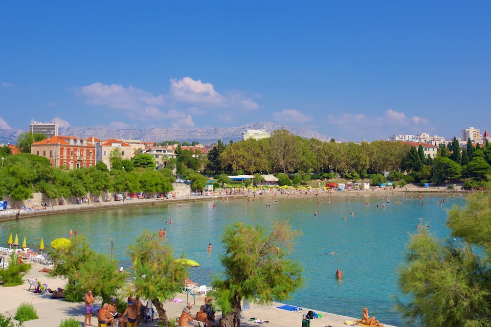 Una città costiera con un'ampia zona balneare pubblica, spiaggia e edifici circostanti.