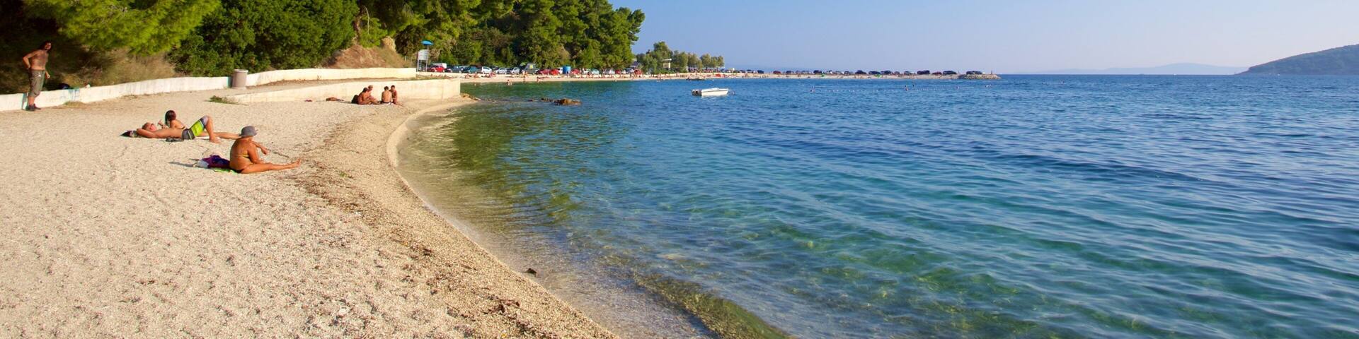 Kasuni-stranden som viser sandstrand og kyst i tillegg til en liten gruppe med mennesker