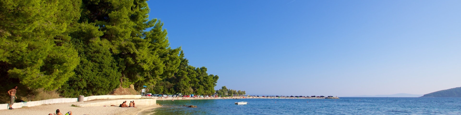 Kasuni Beach which includes general coastal views and a beach as well as a small group of people