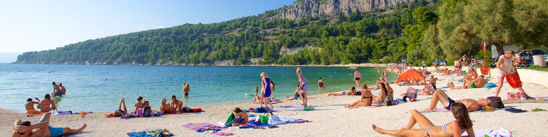 Kasuni Beach which includes general coastal views and a beach as well as a large group of people