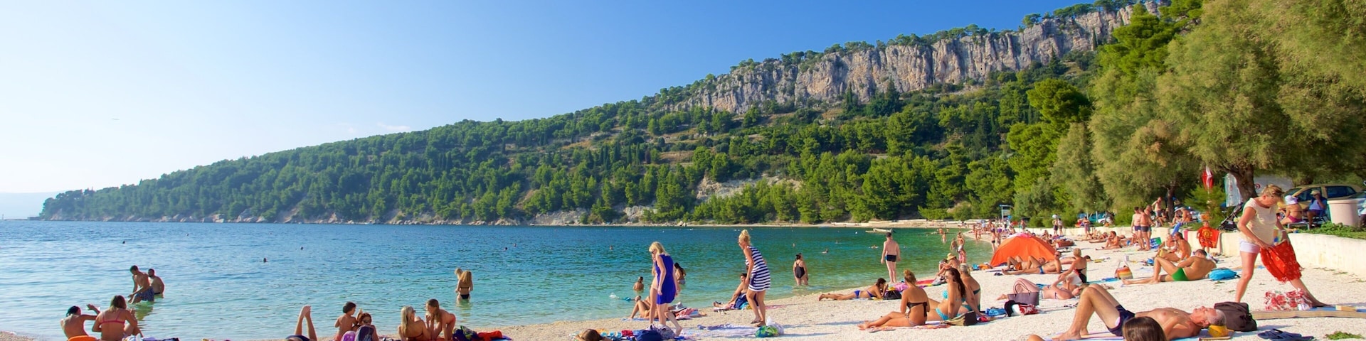 Kasuni Beach which includes a beach and general coastal views as well as a large group of people