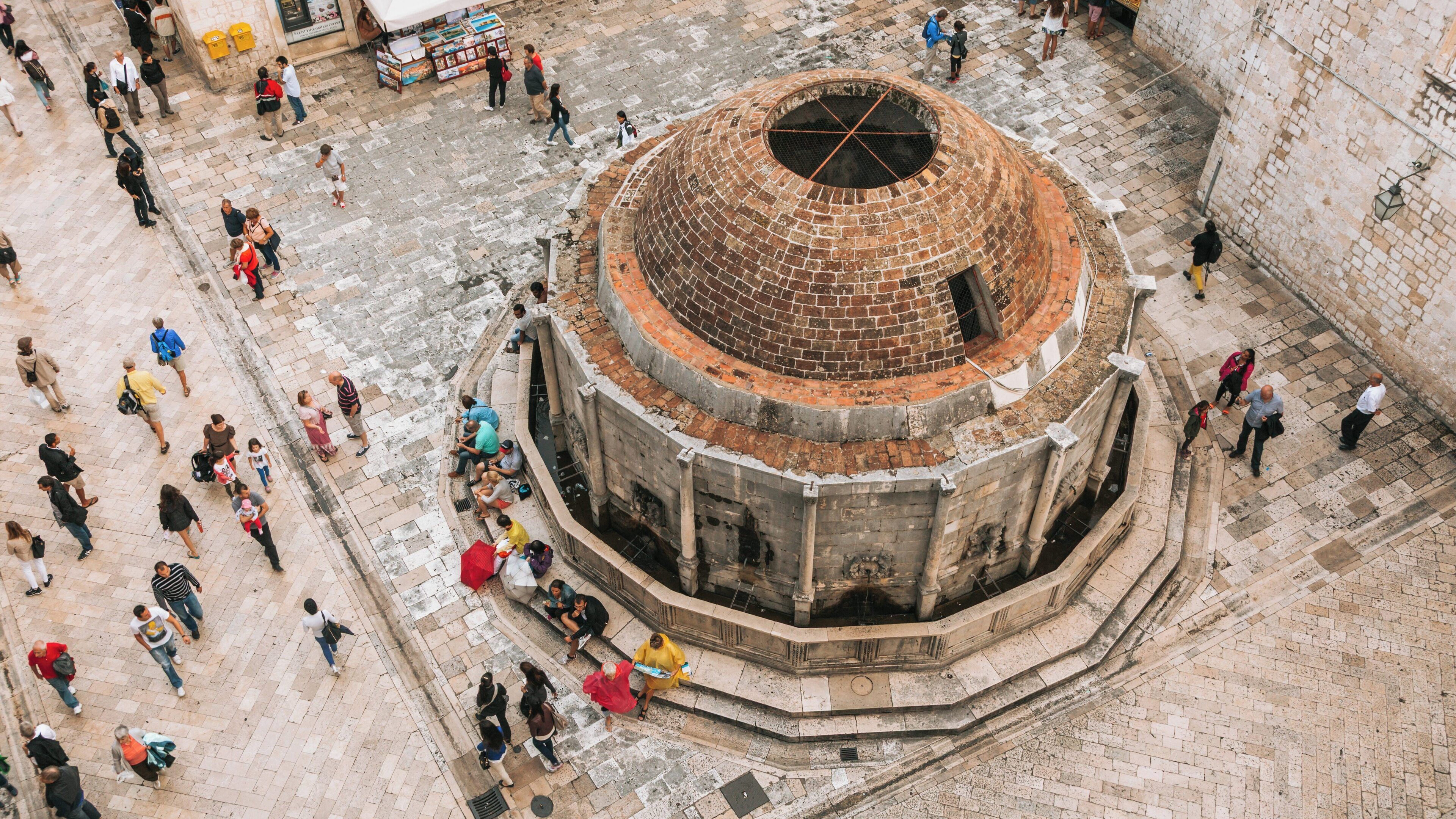 Onofrio's Fountain is a historic landmark in Dubrovnik Old Town, Croatia, surrounded by lively crowds and scenic architecture on a sunny day