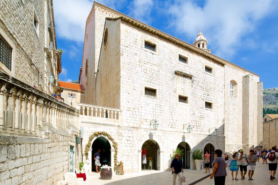 A historic stone building with arched doorways and a bell tower.