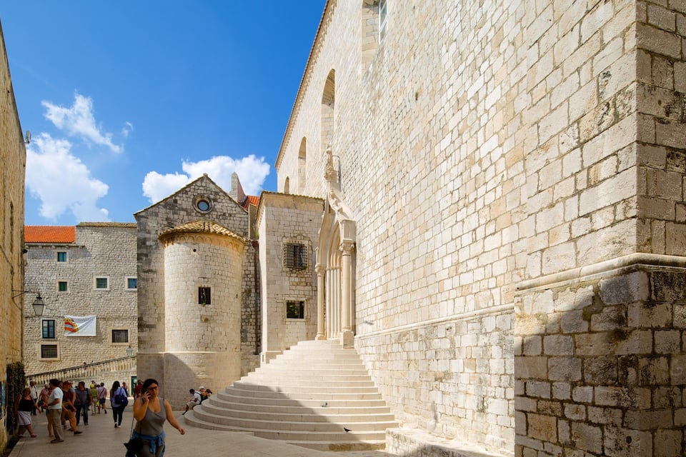 Una escala de pedra que condueix a un edifici històric amb teulada d'estil antic.