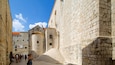 A stone staircase leading up to a historic building with a tiled roof.
