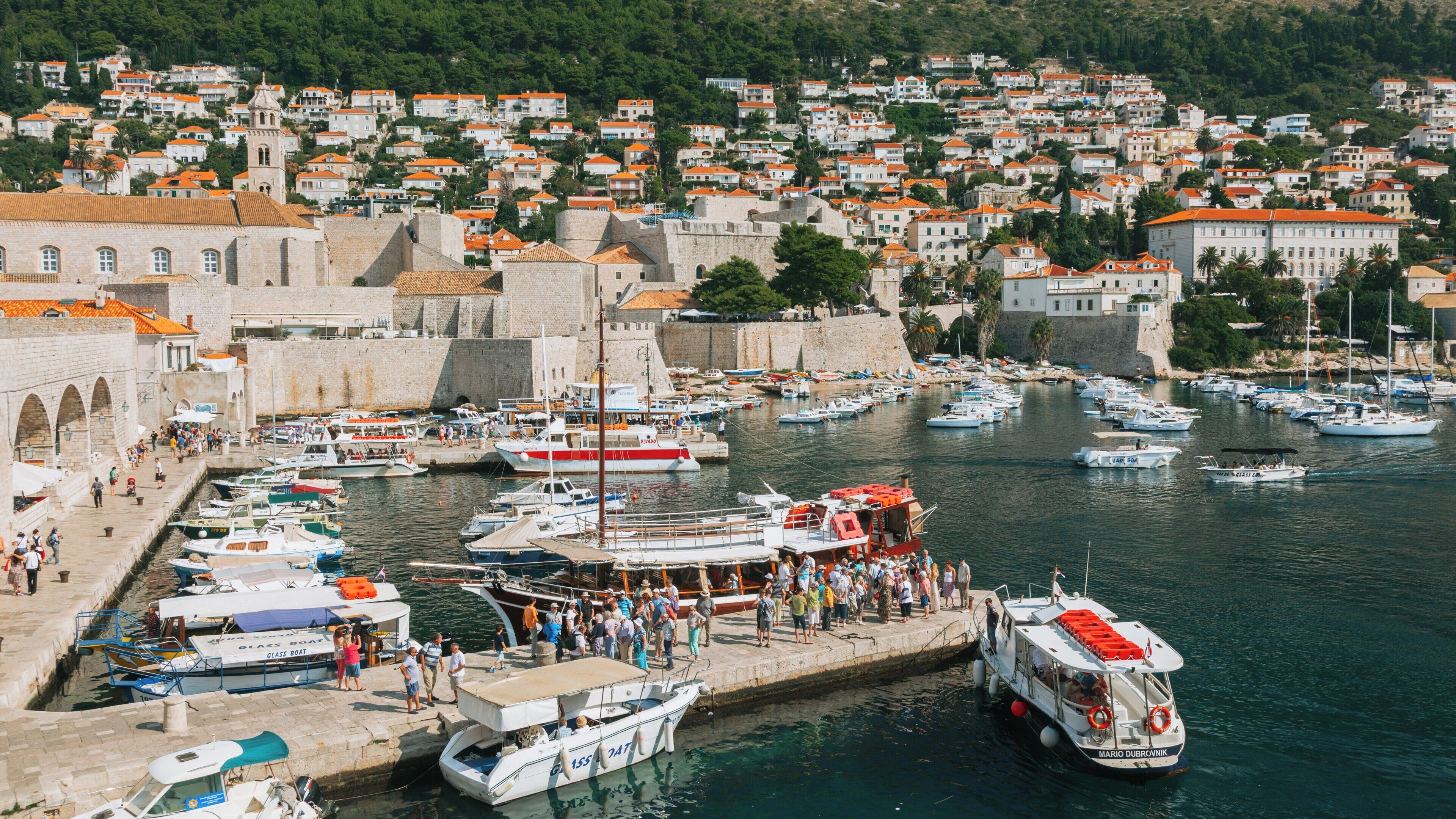 Revelin Fortress and the bustling harbor of Dubrovnik, Croatia, showcasing historic architecture and vibrant activity