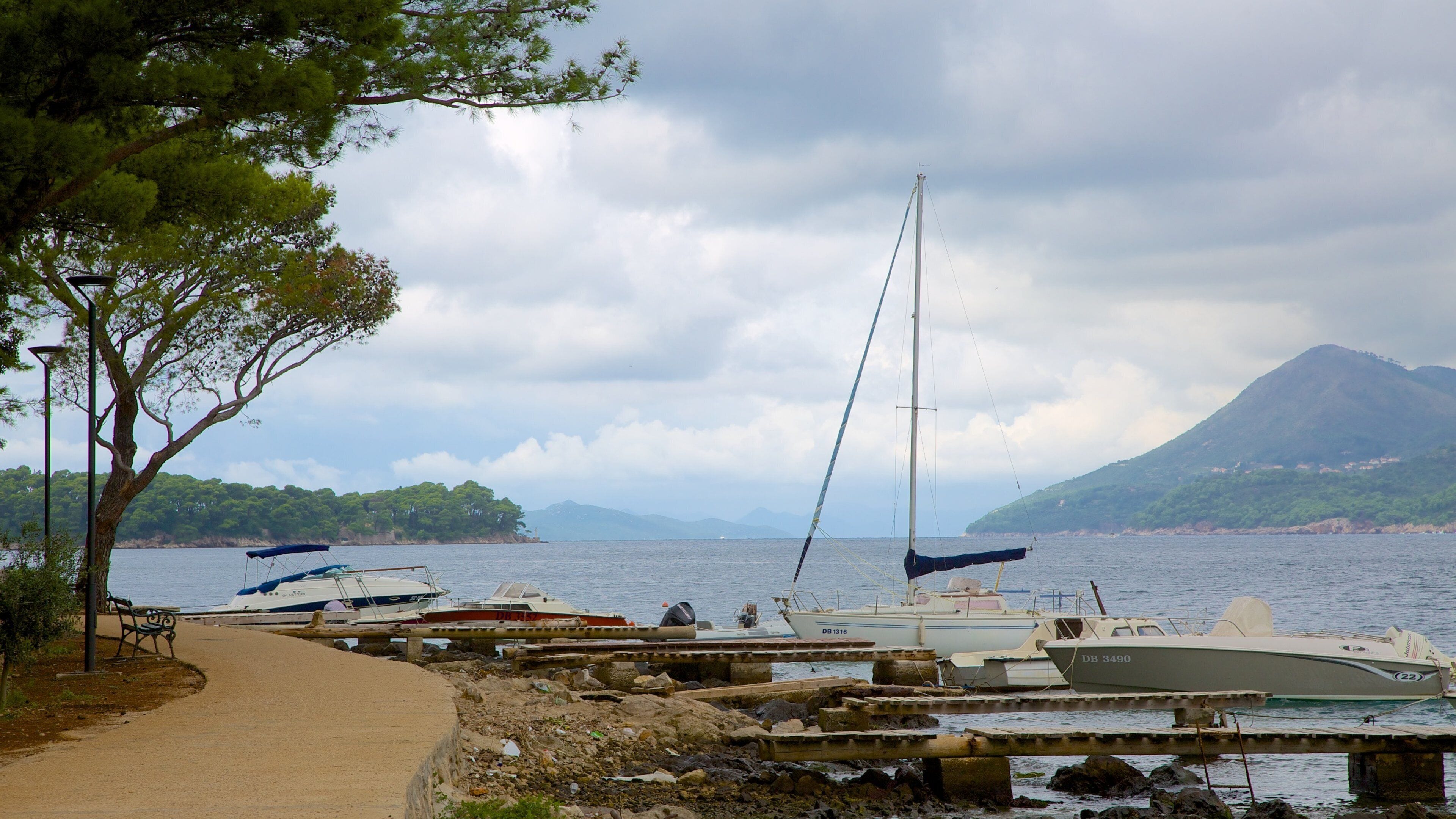 Lapad Beach featuring a bay or harbor and a lake or waterhole