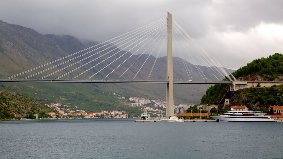 Lapad Beach showing a lake or waterhole, mountains and a bridge