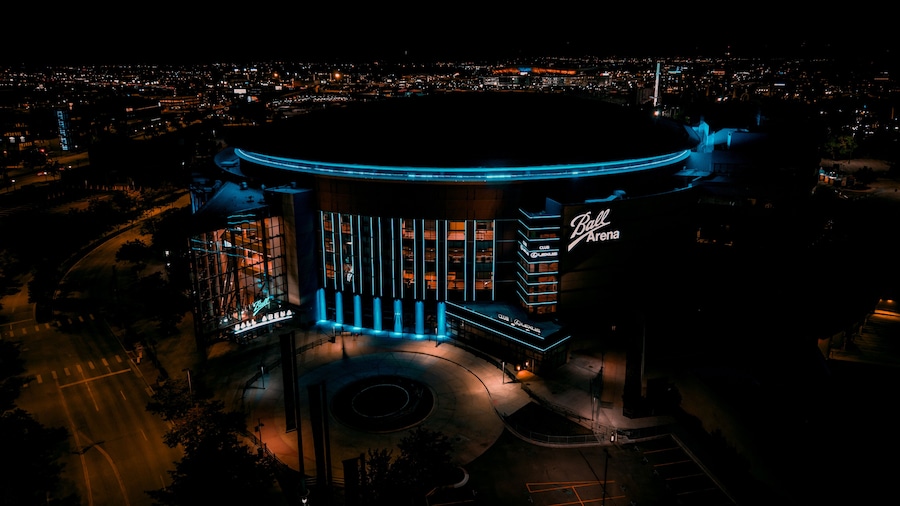 Aerial view of the luminous Ball Arena stands brightly against the dark sky, a beacon in the night, Denver, Colorado, United States.