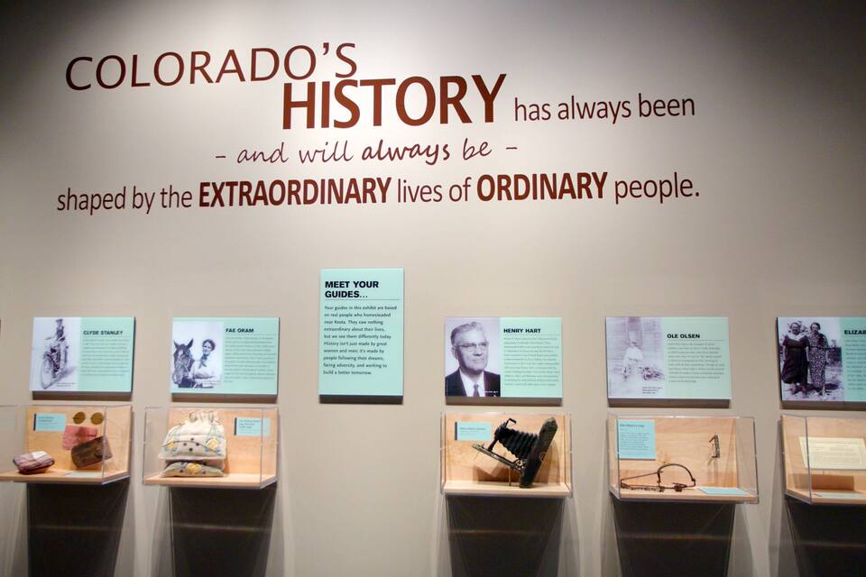 A museum exhibit titled 'Colorado's History' with displays of historical artifacts and photographs.