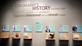A museum exhibit titled 'Colorado's History' with displays of historical artifacts and photographs.