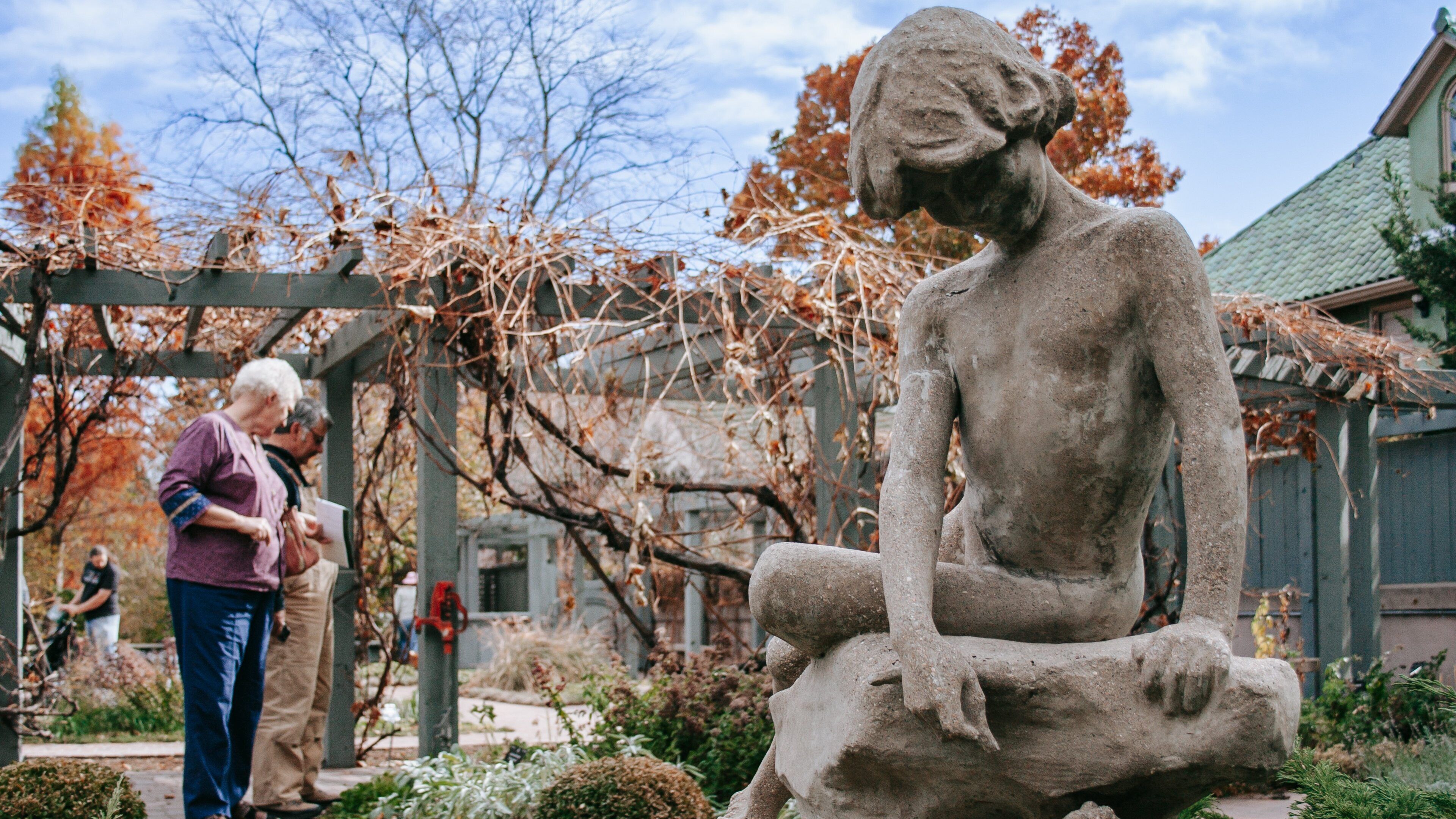 Denver Botanic Gardens featuring a statue or sculpture and a park as well as a couple