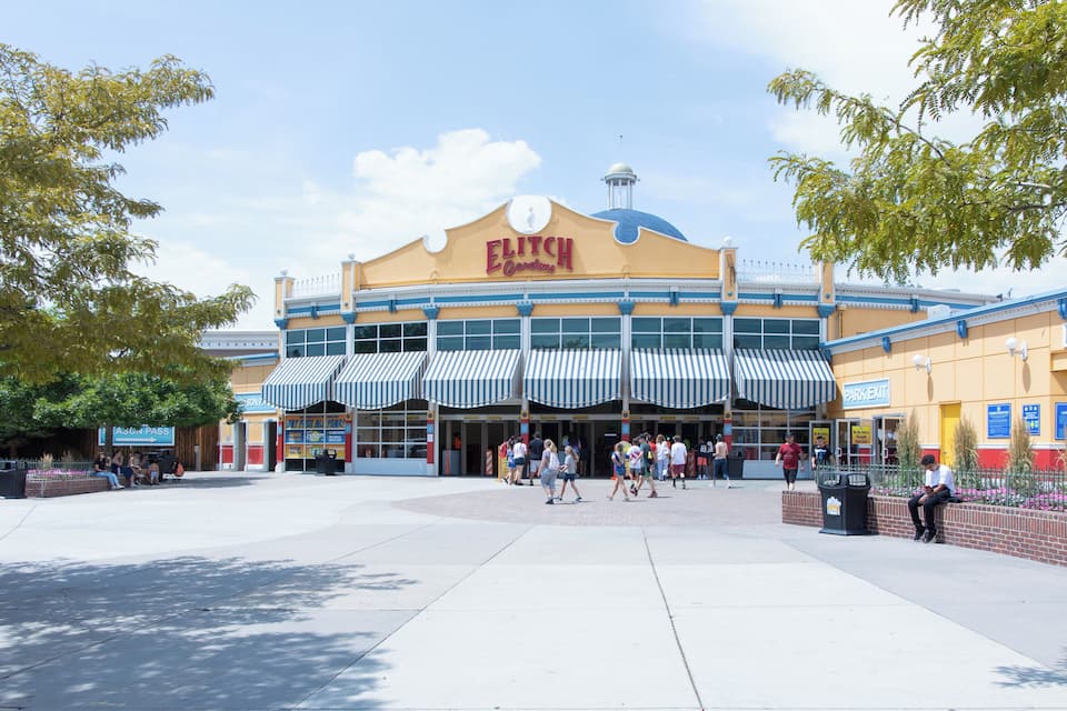 A large, yellow building with a blue dome and striped awnings, labeled "ELITCHUR Gardens."