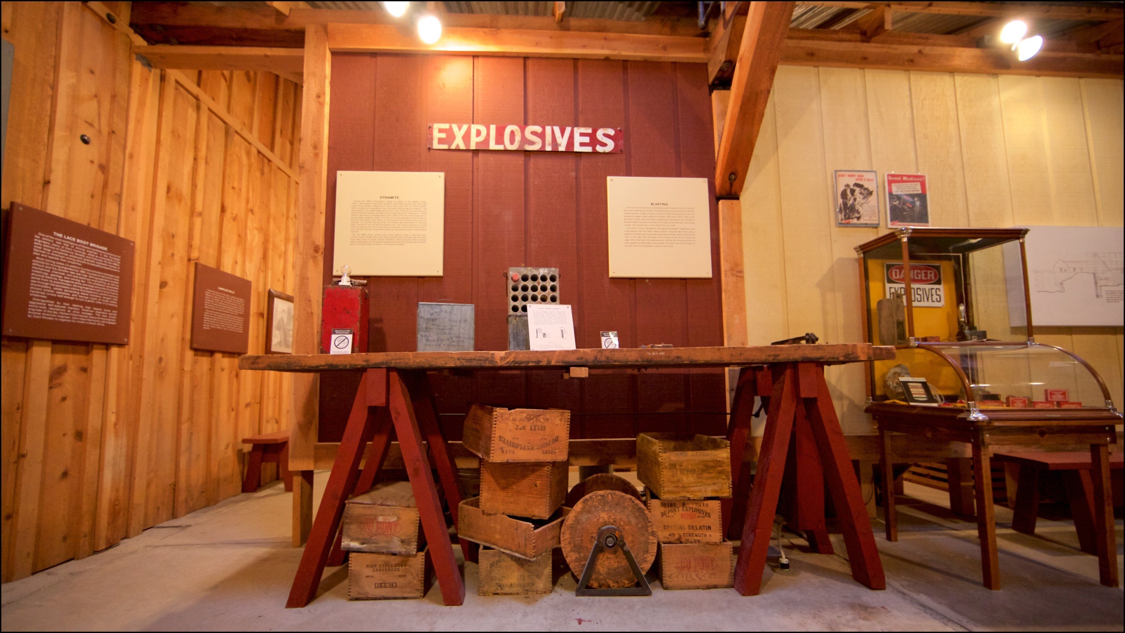 Une exposition d’explosifs, avec des caisses en bois et des panneaux d’information.