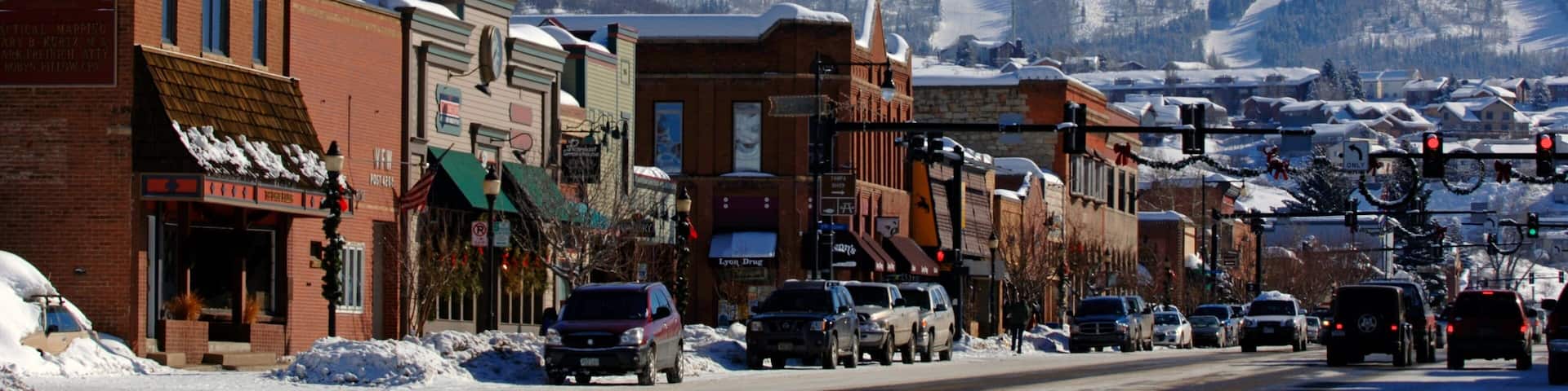 A snowy mountain town with buildings and cars.