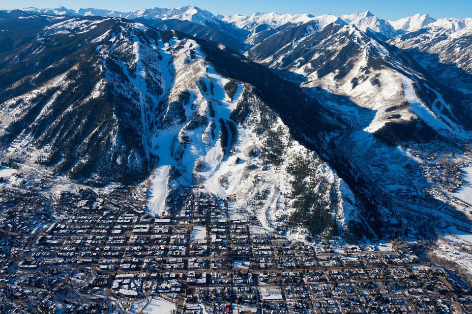 Una cordillera nevada con un pueblo a su base.