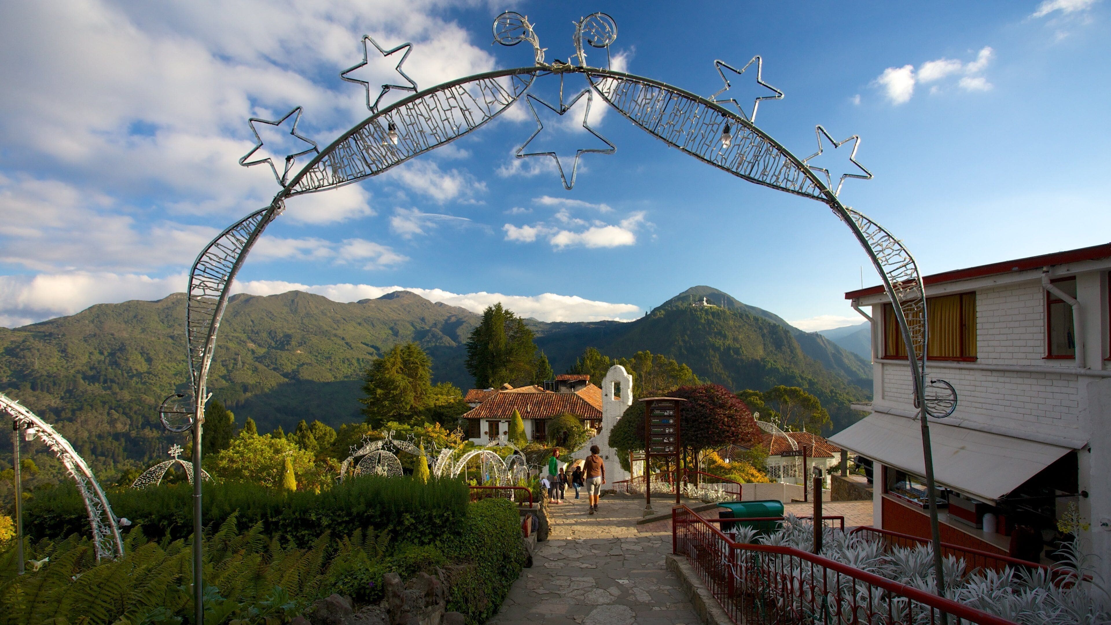 Paisagem montanhosa com um arco de metal decorado com estrelas.