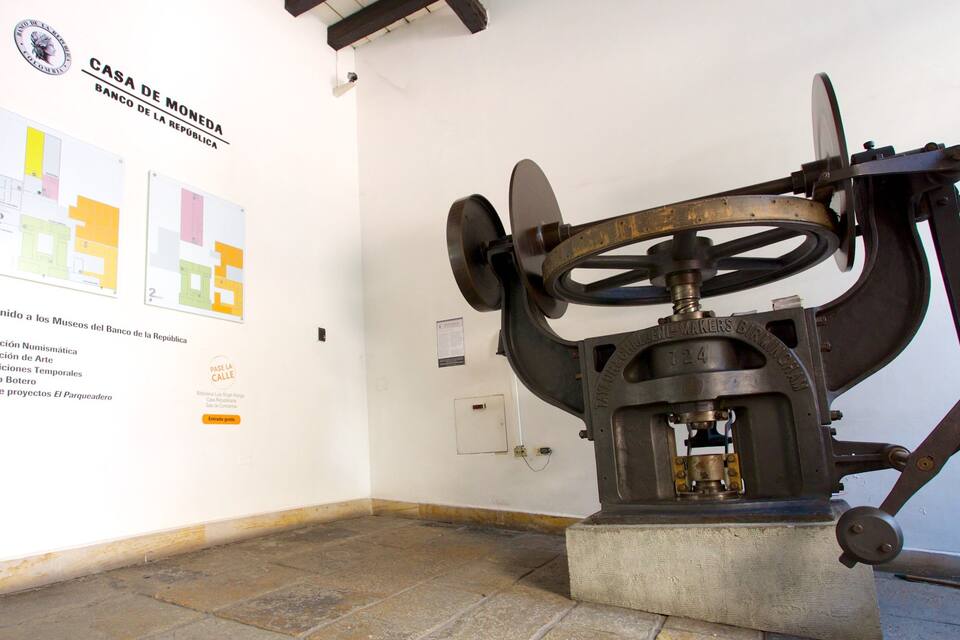 En mekanisk konstruktion, måske et historisk artefakt, i en museumsudstilling med informationsplakater på væggen.