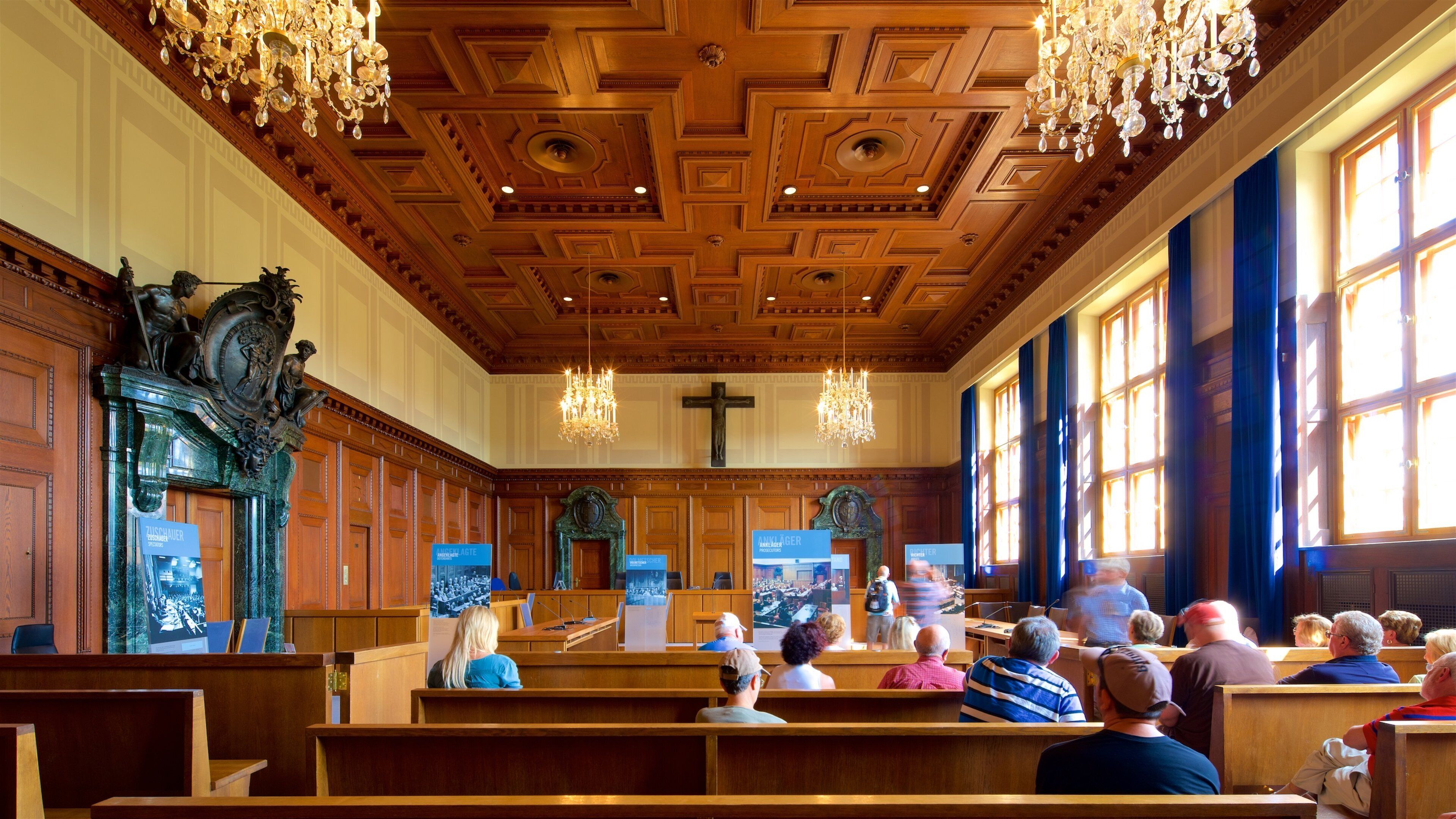 A church interior with wooden pews, a wooden ceiling with intricate patterns, and a large cross.