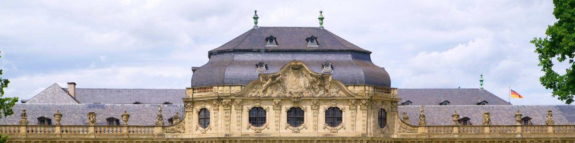 A grand historic building with ornate architecture, large windows, and a central dome.