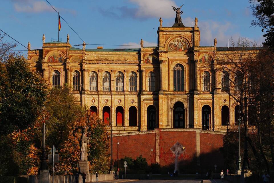 A historic building with ornate architecture, including a statue on the roof and a mural on the facade.