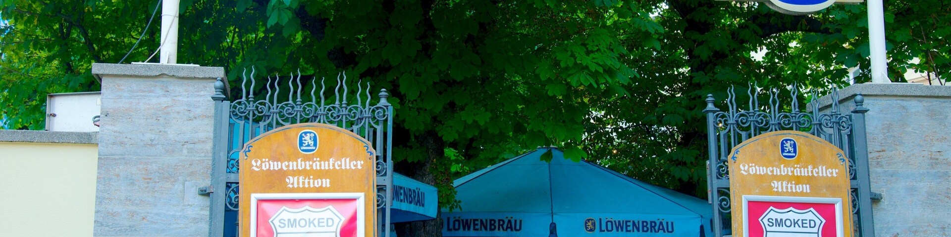 Lowenbrau showing outdoor eating and signage as well as a large group of people