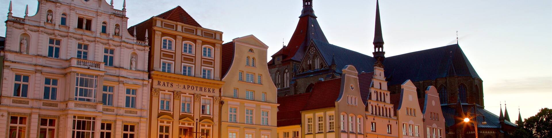 Historic buildings with ornate facades and a church with a tall spire.