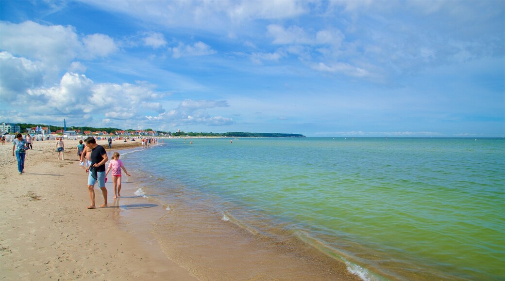 Warnemunde Beach which includes a sandy beach and general coastal views as well as a small group of people