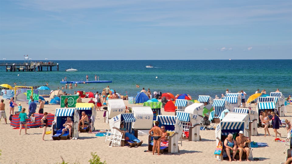 A crowded beach with people sunbathing, tents, and beach chairs.
