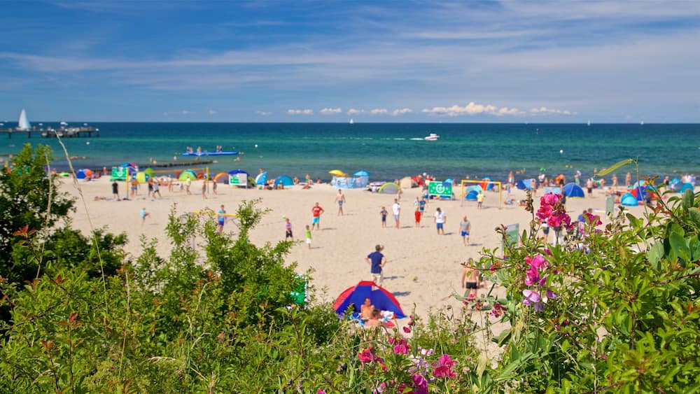 Ein Strand mit Menschen, Zelten und Booten.