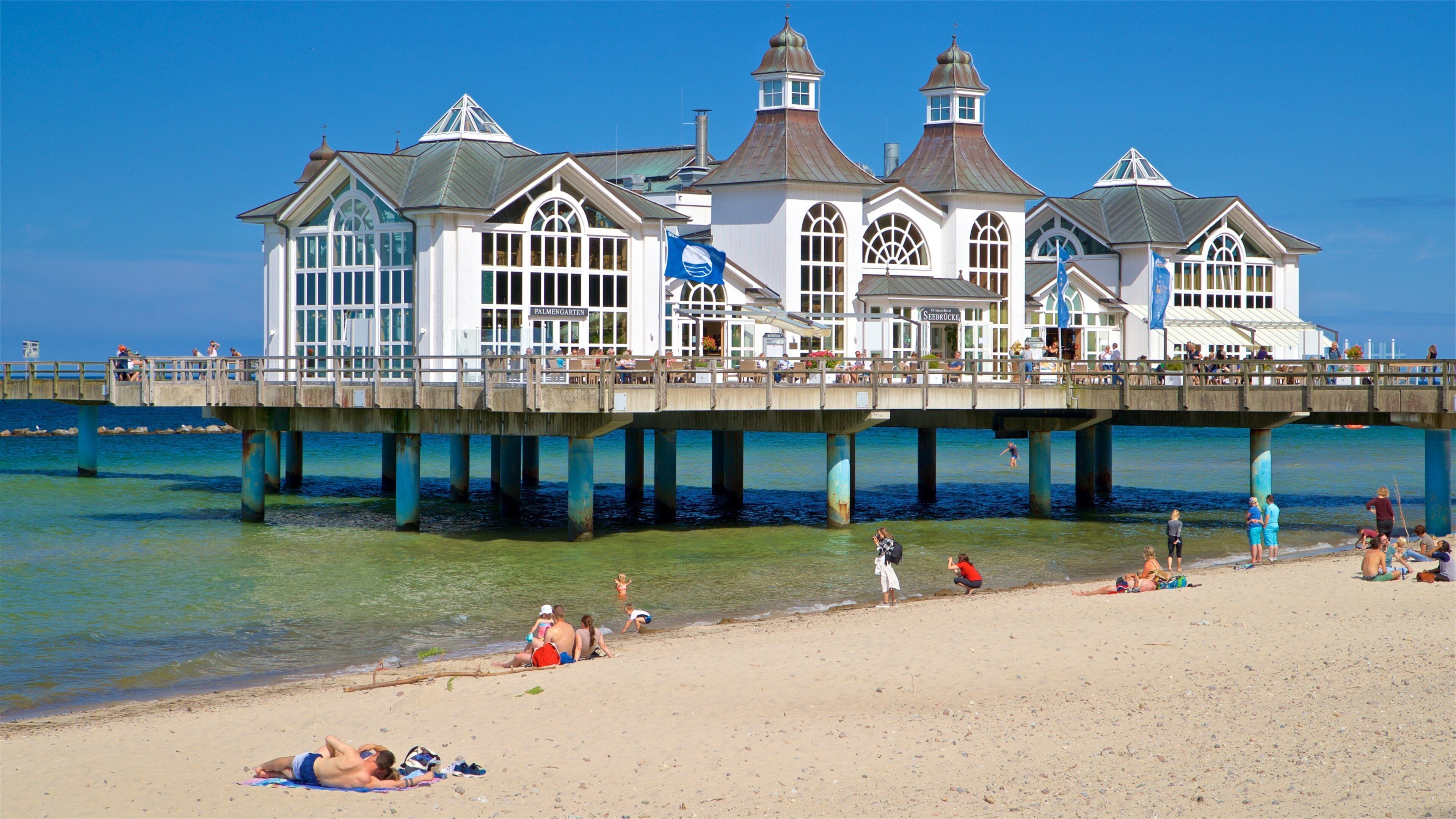 Sellin Pier featuring a beach and general coastal views as well as a small group of people