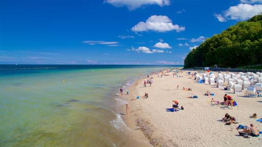Sellin Pier showing a sandy beach and general coastal views as well as a small group of people