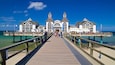 Sellin Pier which includes general coastal views and a sandy beach as well as a small group of people